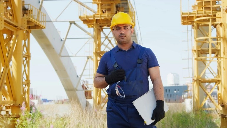 Construction worker at a construction site. Has hard hat for safety.